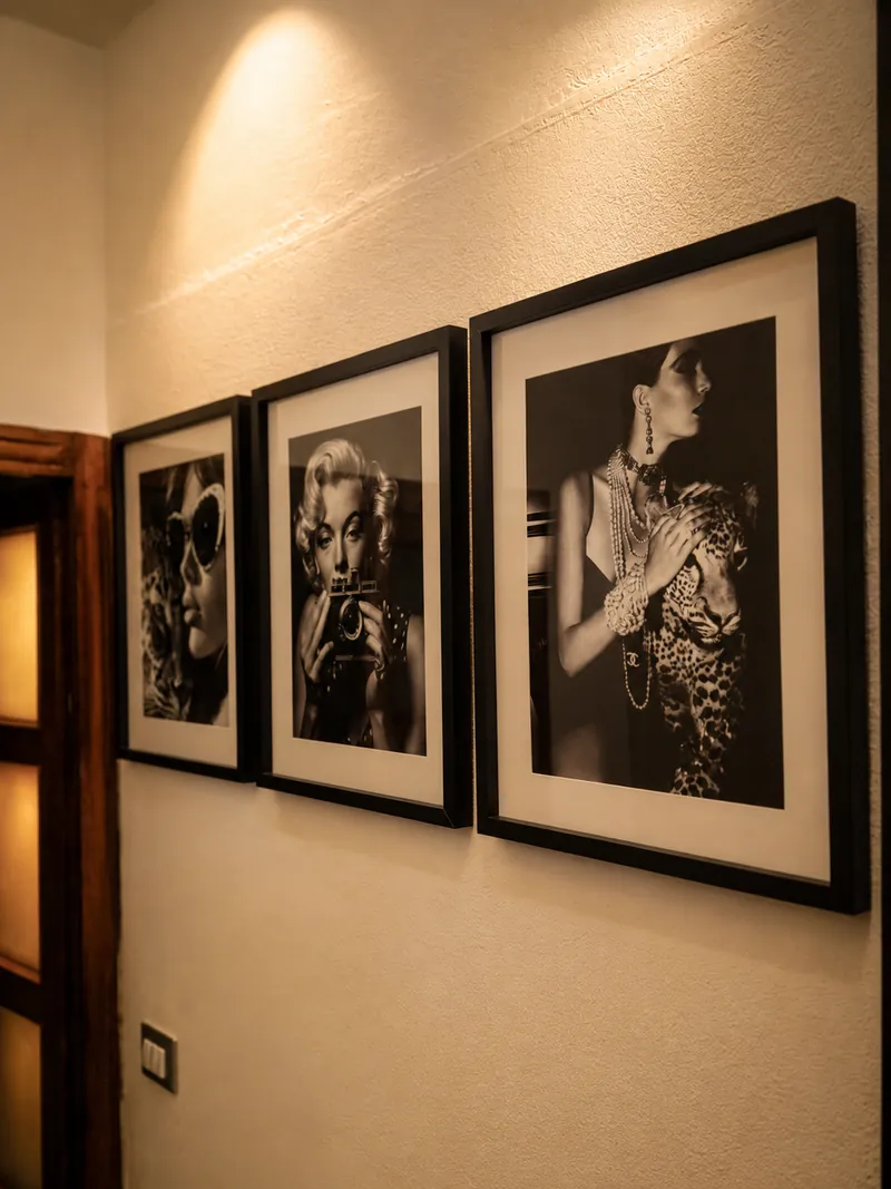 Black-and-white framed portraits lining the hallway wall