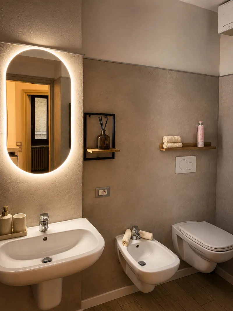 Bathroom with a softly lit oval mirror and stone-effect walls